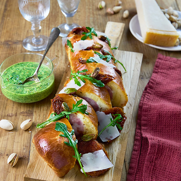 Saucisson brioché rôti farci, roquette et tomates confites au pesto de pistache